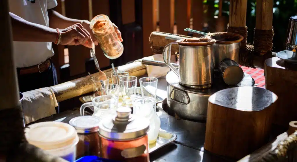 Man making a traditional thai tea or coffee on counter for sale